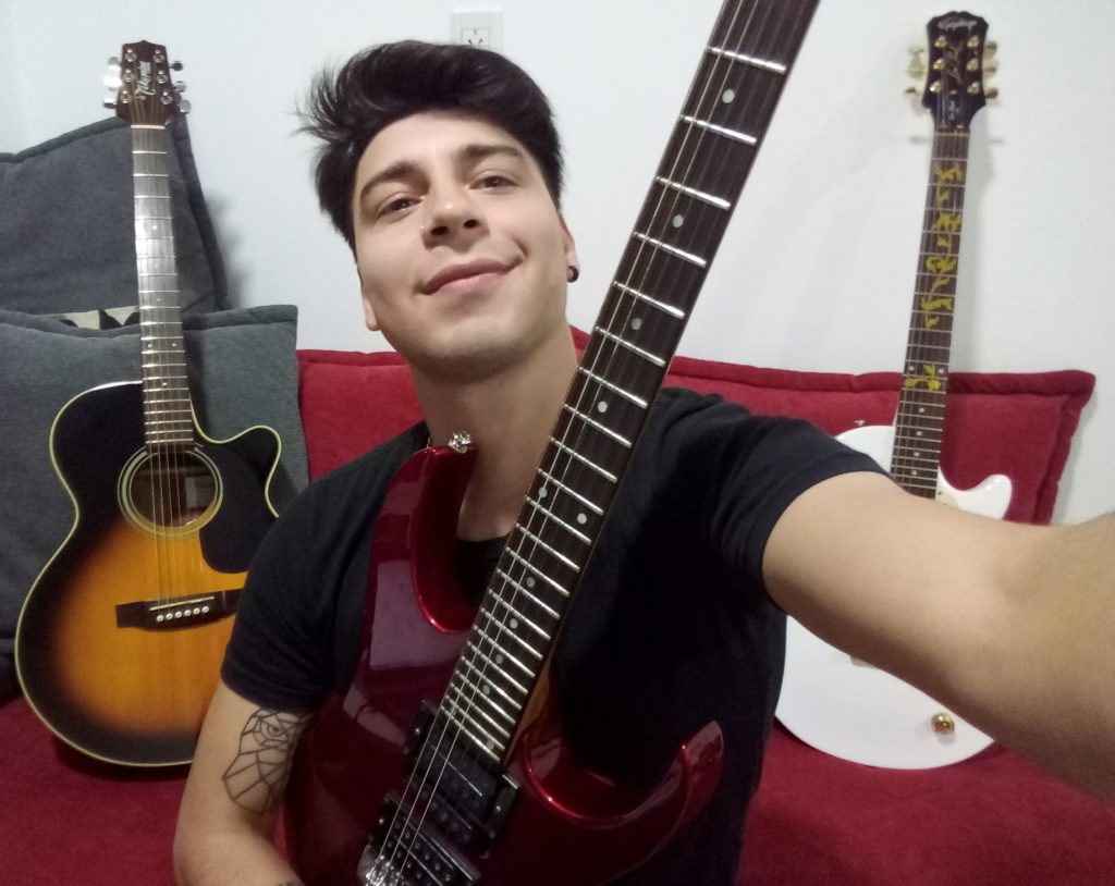 CLAUDIO GRASSI – con una guitarra de empresa rusa a recibir,  vende números de rifa para solventar gastos y seguir soñando vivir de la música.